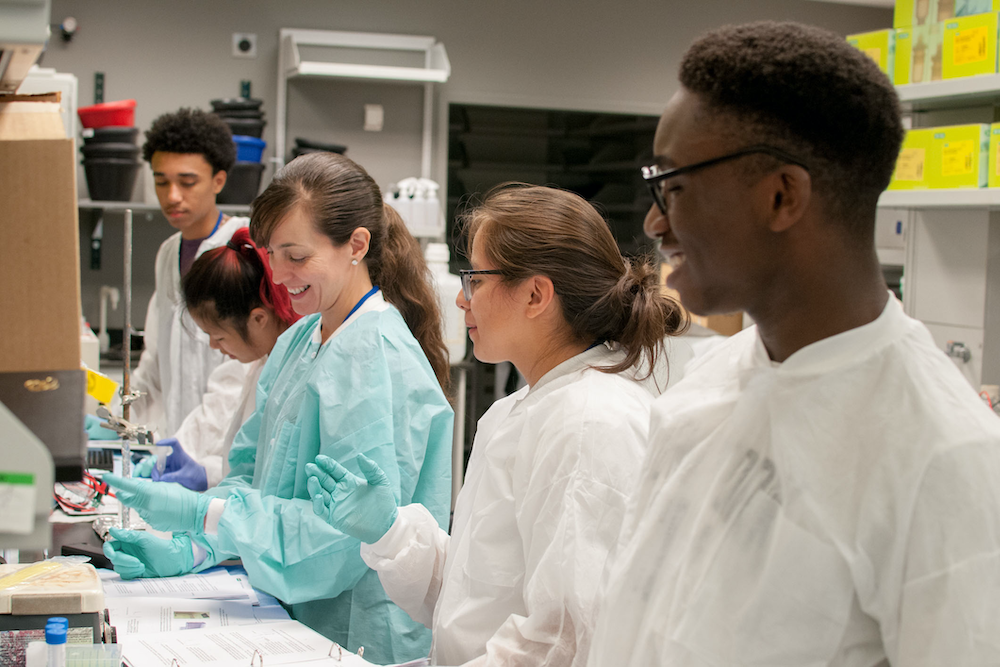 Group of biomedical researchers collaborating in a laboratory setting.